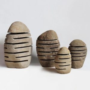 Natural oval river stone garden lamp collection on a white background